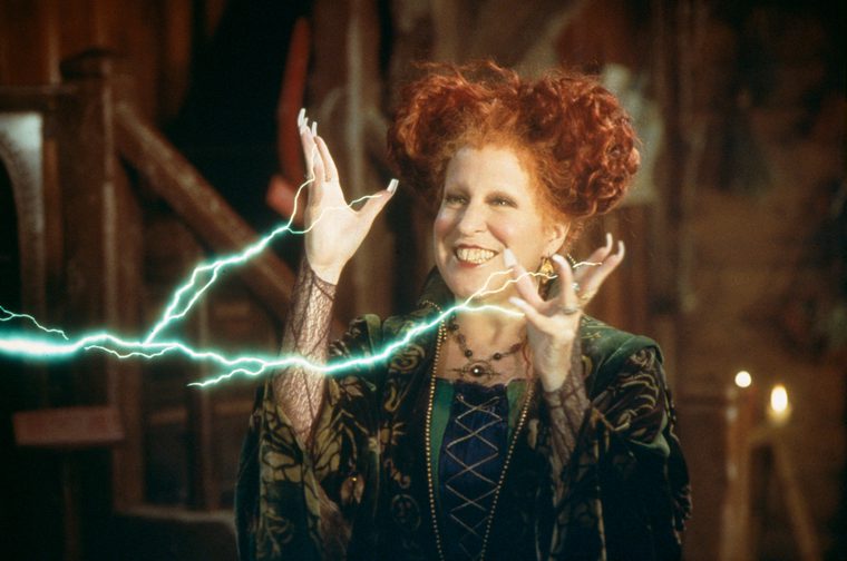 Bette Midler smiles as she unleashes green electricity from her hands.
