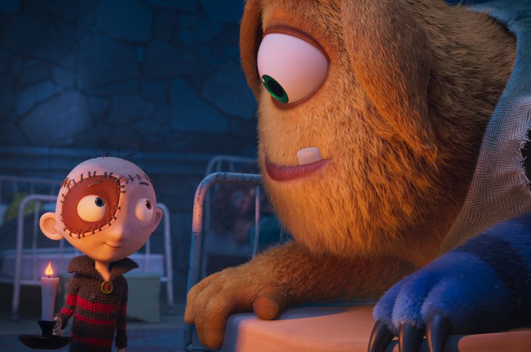 The animated image shows two characters - a small child character with distinctive features including mismatched eyes and stitched-looking hair, wearing a dark striped sweater and holding a candle in a candlestick holder. They're looking up at a much larger character who appears to be some kind of creature or monster with orange/brown fur, large expressive eyes with green irises, and a gentle, friendly expression.