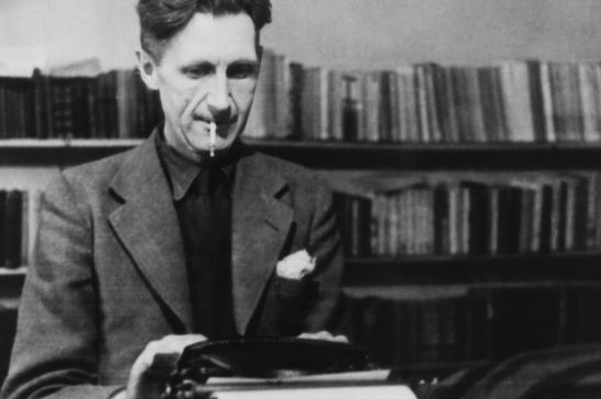 We see a black and white photograph of a man (author George Orwell) sitting at a typewriter with a cigarette in his mouth, surrounded by bookshelves in the background.
