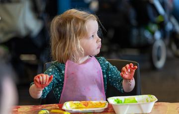 Little girl with messy hands from paint