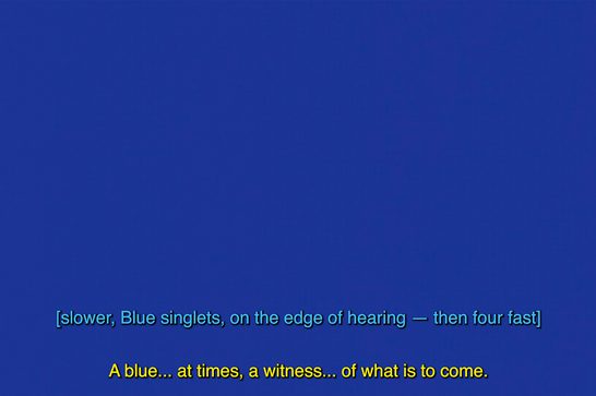 A solid blue image featuring subtitles in a lighter blue saying 'slower, blue singlets, on the edge of hearing - then four fast.' Below are yellow subtitles saying 'A blue...at times, a witness...of what is to come.'