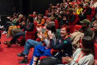 Audience clap in cinema, woman smiles at the camera