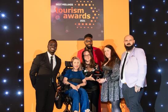 A group of people smile having received an award.