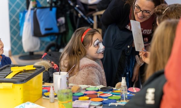 Young girl gets her face painted as a rabbit
