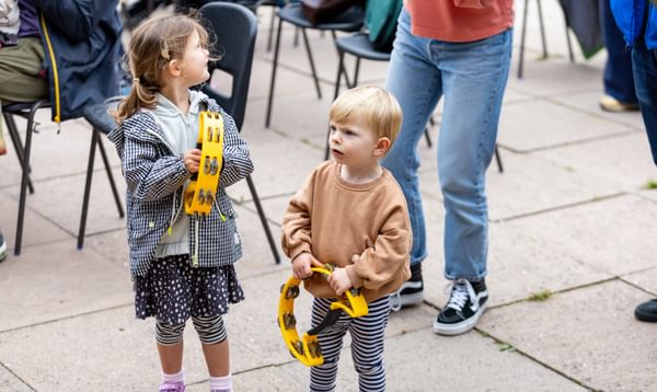 Two children holding tambourines