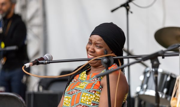 Woman smiles sat behind a microphone on stage
