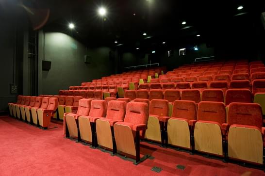 Wide view of empty red seats in MAC's Cinema