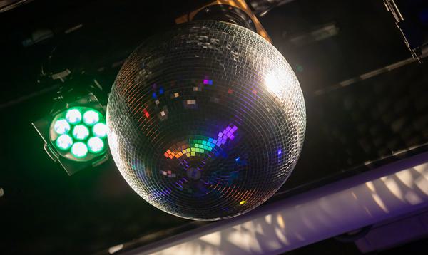 A disco ball hangs from the ceiling, next to a green light