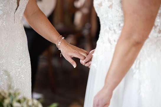 A close up of two brides holding hands