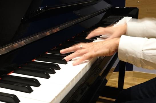 Blurred hands are moving over piano keys