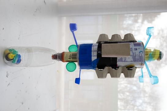 A plastic bottle with an attachment on top, made from plastic and cardboard