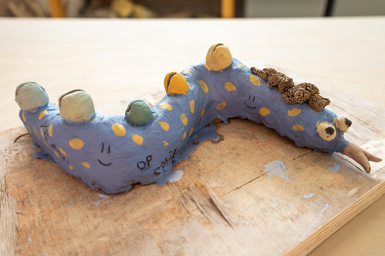 A colourful blue and yellow painted clay worm