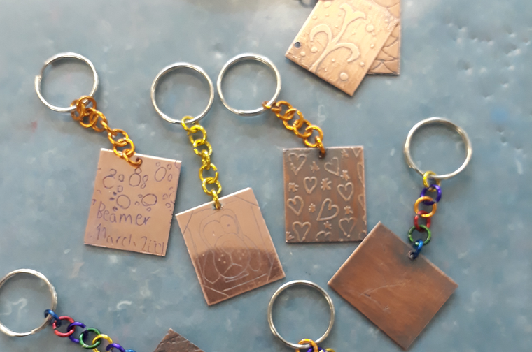 a collection of copper rectangle keyrings, with fun engravings on the front