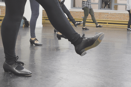 People in a dance studio, with their leg outstretched