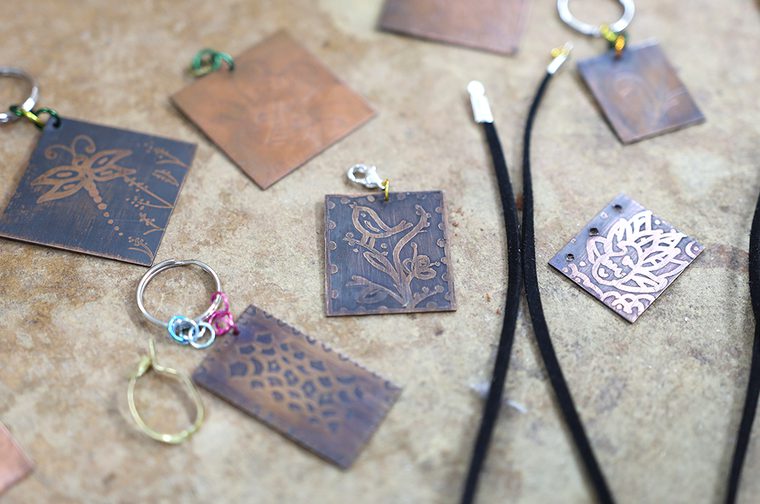 A collection of keyrings, with etched drawings on them
