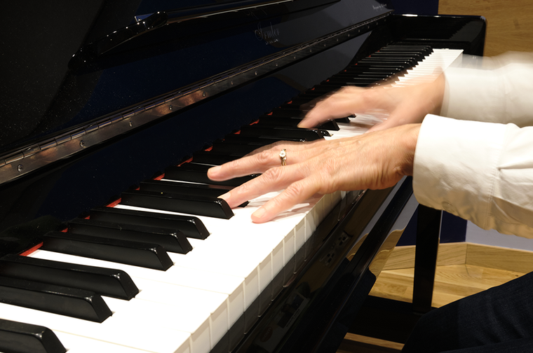 A person is moving their hands across the piano keys