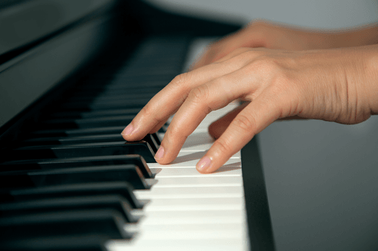 A person is moving their hands along piano keys