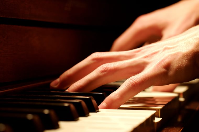 Someone's hands are moving across a piano