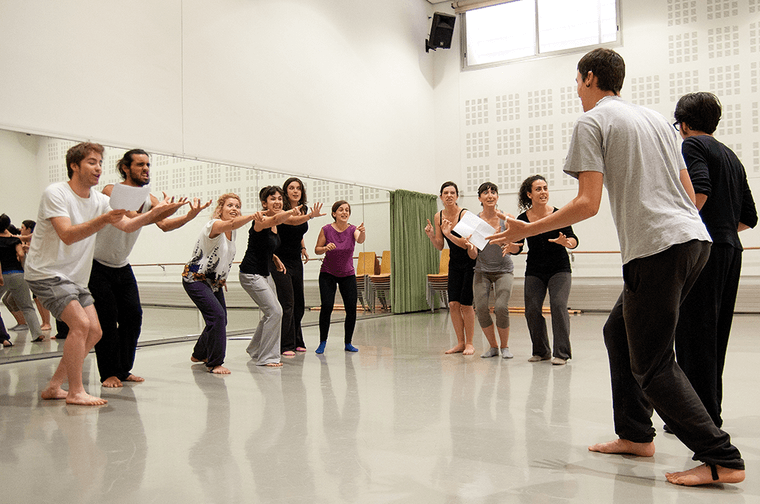A group of people gathered in a circle, making expressive hand gestures