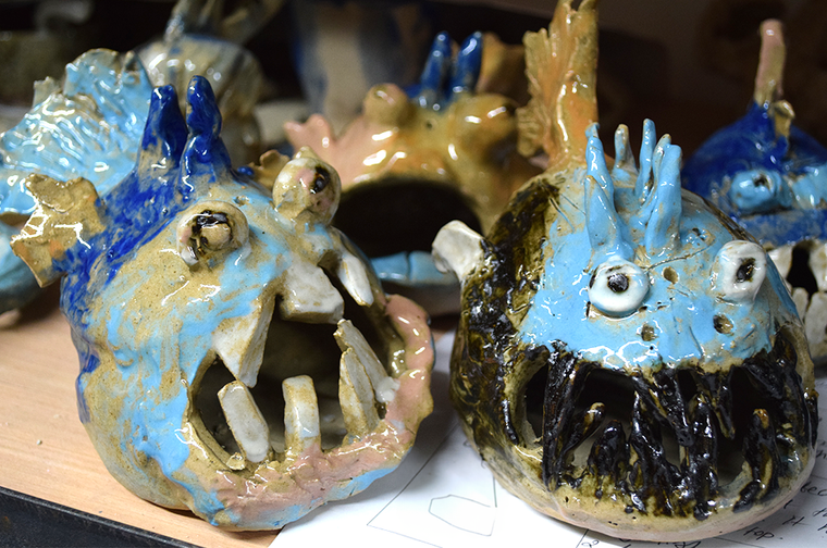 A collection of fish made from clay, with jagged teeth and bulging eyes