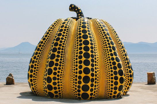 Orange pumpkin with small and large black dots covering it