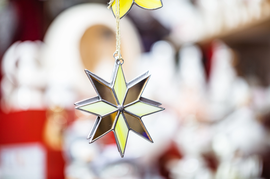 A small yellow, white and grey star made from glass