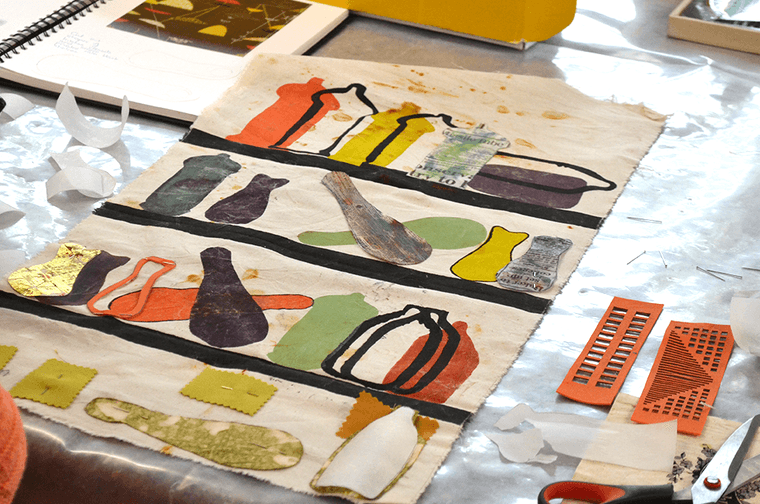 A piece of fabric, with colourful bottle shapes printed in various methods on it