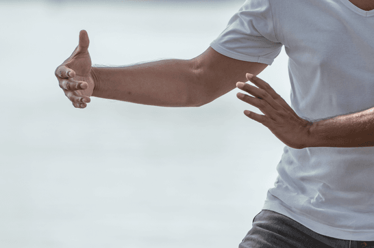 A close up of someone's hands outstretched in a Tai Chi pose