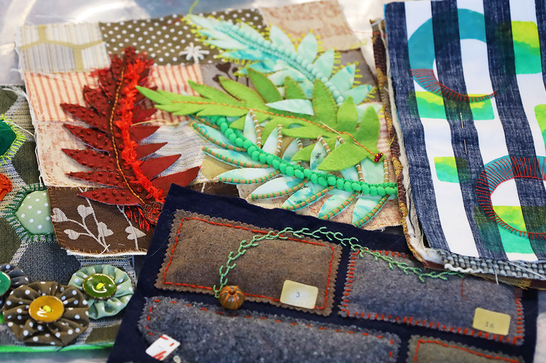 A collection of textile materials, sewn into leaves and patches.