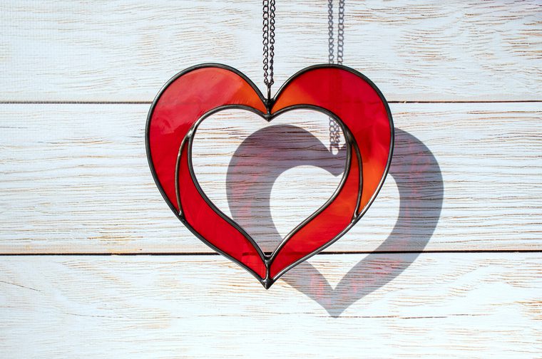 A red stained glass heart handing on a chain