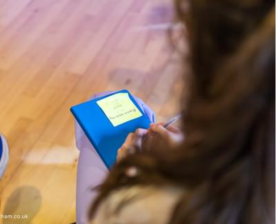 Over the shoulder view of a women with her note book