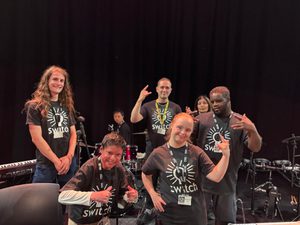 SWITCH band wearing matching SWITCH T-shirts posing for a group photo