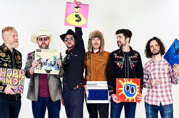 The band Independent Country: 6 men in country music outfits holding vinyl sleeves of classic indie albums including Never Mind and Definitely Maybe.