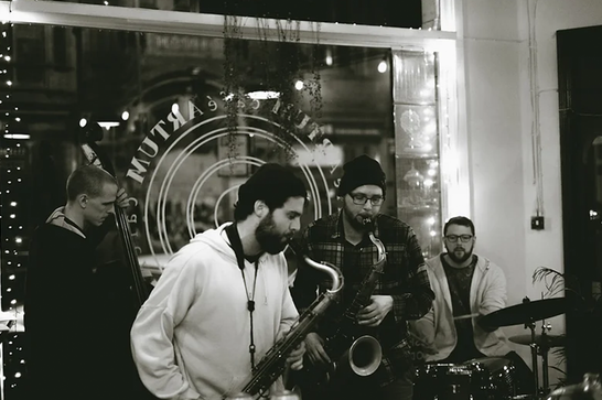 A jazz band made up of a double bass player, two saxophonists, and a drummer.