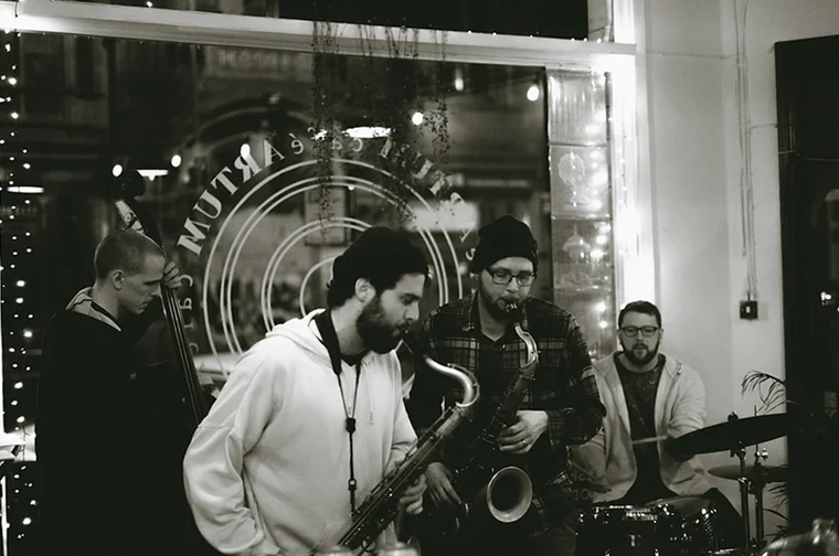 A jazz band made up of a double bass player, two saxophonists, and a drummer.