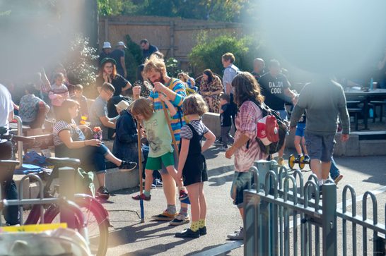 Families play outside with father and child on stilts
