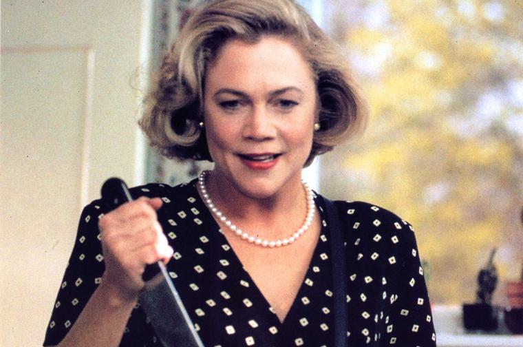 Kathleen Turner clutches a large kitchen knife, reday to stab somebody.