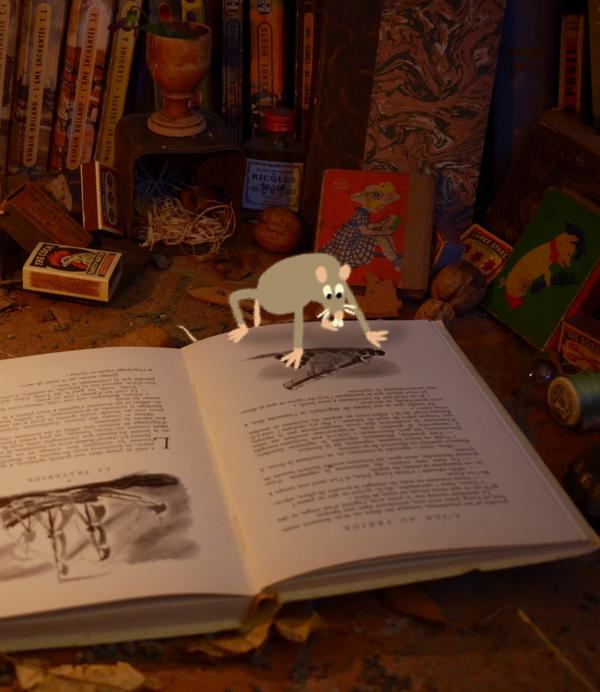 A grey cartoon mouse sits on a book that has an illustration of an old ship on it. A lit candle sits next to the book.