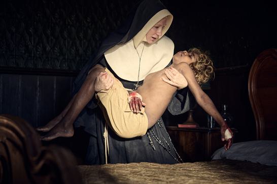 A distraught nun (Cate Blanchett) holds an unconscious Indigenous boy who has bloody bandages on both hands.