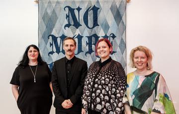 Ben Venom, family and MAC staff stand in front of a quilted artwork