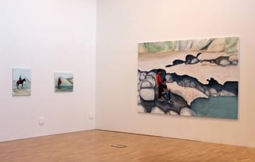 Artworks hung on a wall in a gallery