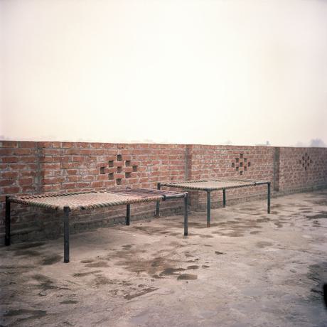 Traditional Pakistani beds (charpai) outside next to a brick wall