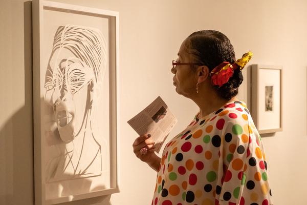 Woman in spotty top looks at artwork in a gallery