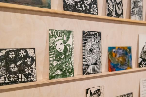 Postcards designed by artist Madge Gill displayed on a shelf