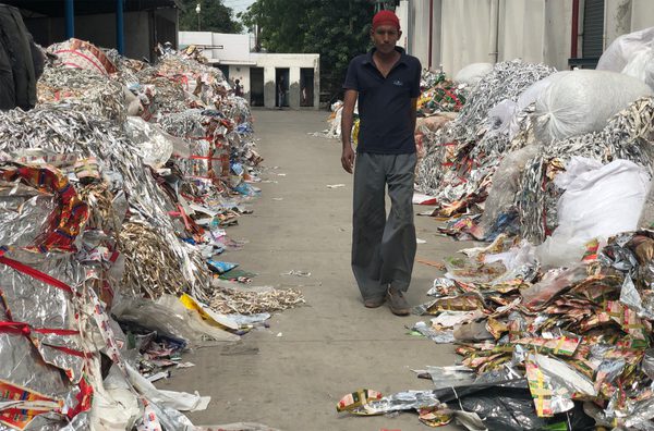A man walks down a path lined with rubbish on either side