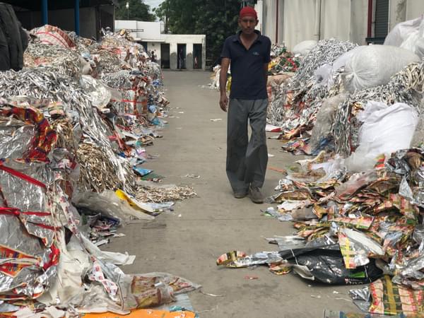 Man walks down a path lined with rubbish on either side