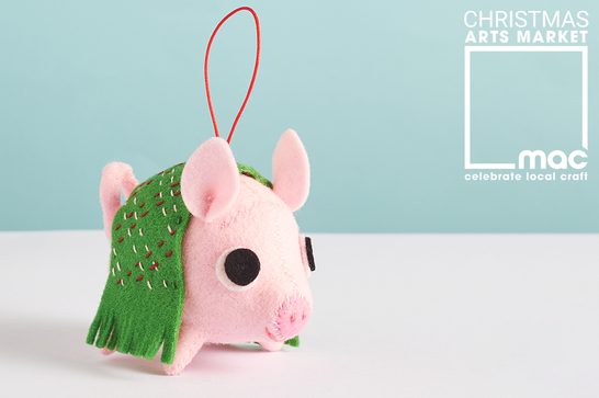 A Christmas decoration made from felt, of a pig in a blanket