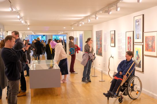 A gallery filled with people, exploring artworks